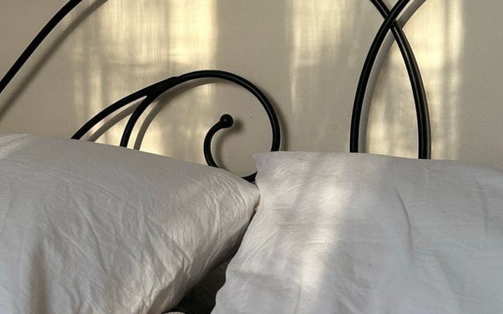 A bright, cozy bed with white pillows